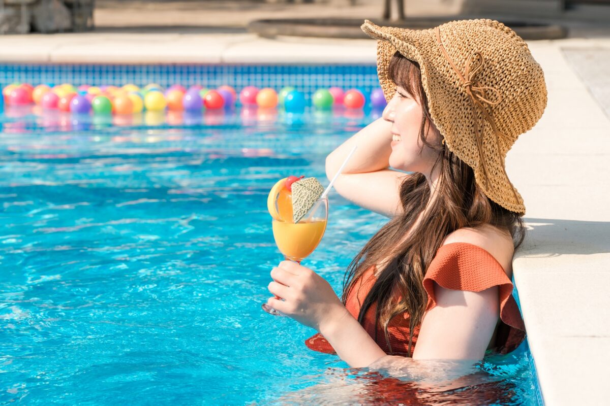 プールで飲み物を飲む女性