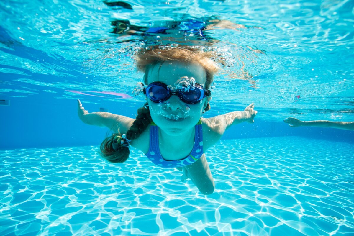 ゴーグルを使ってプールで潜る女の子